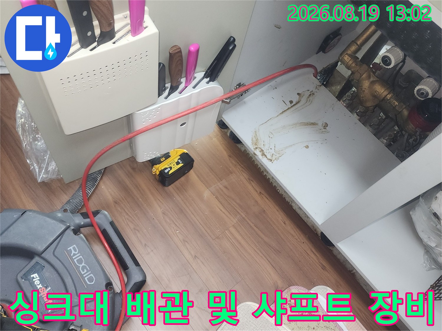 싱크대 하부의 오염된 배관과 작업용 리지드 샤프트 케이블입니다.