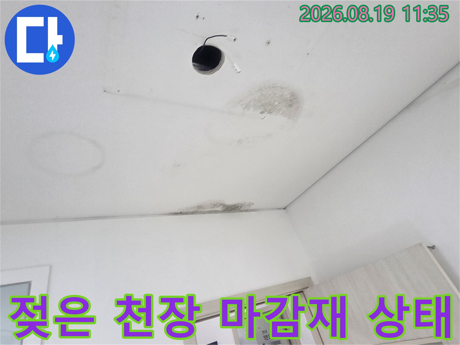 천장 조명 주변에 나타난 짙은 색의 누수 얼룩과 변색