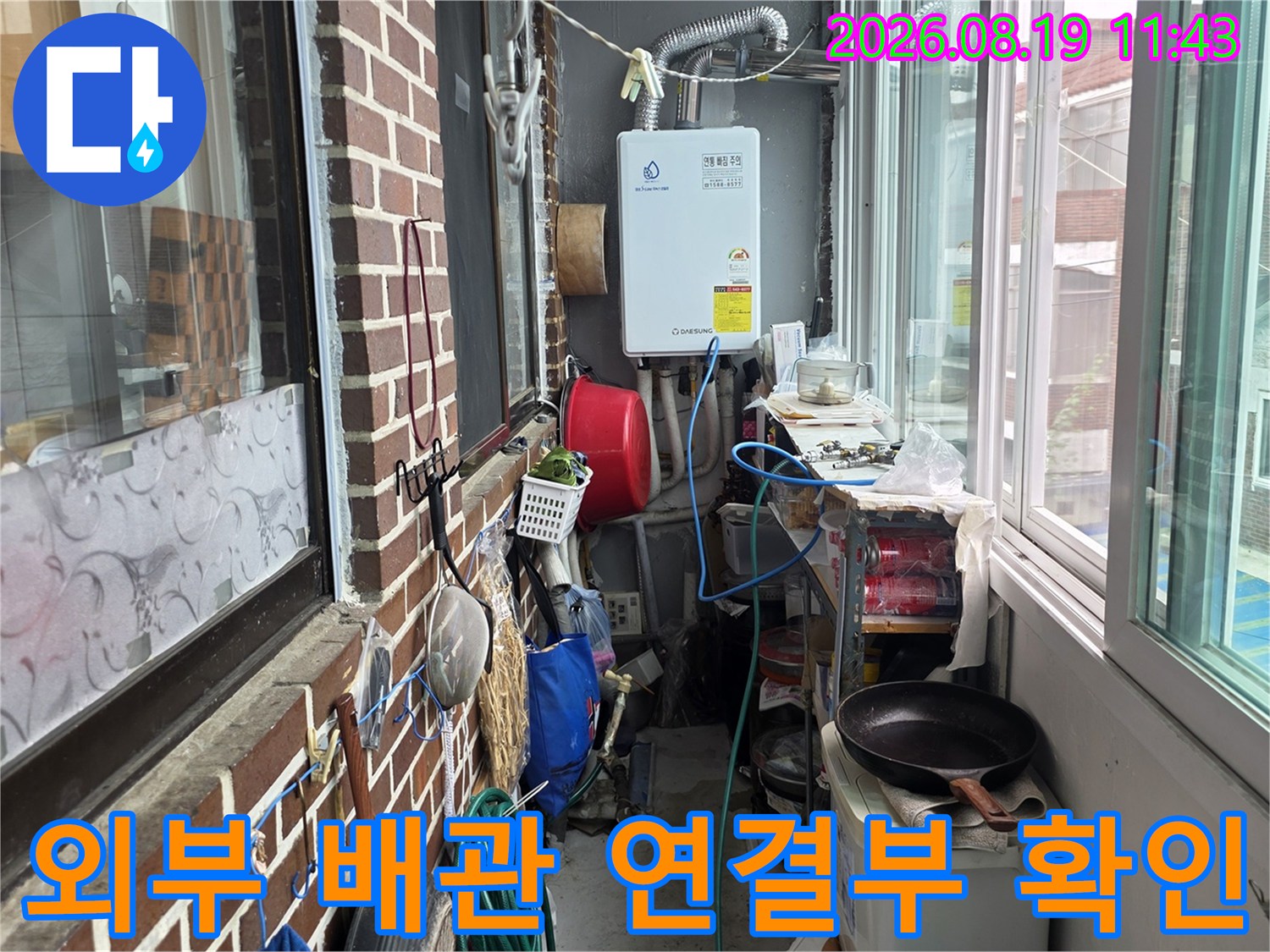 보일러와 외부 벽돌 마감 사이의 배관 노출 상태를 촬영한 사진입니다