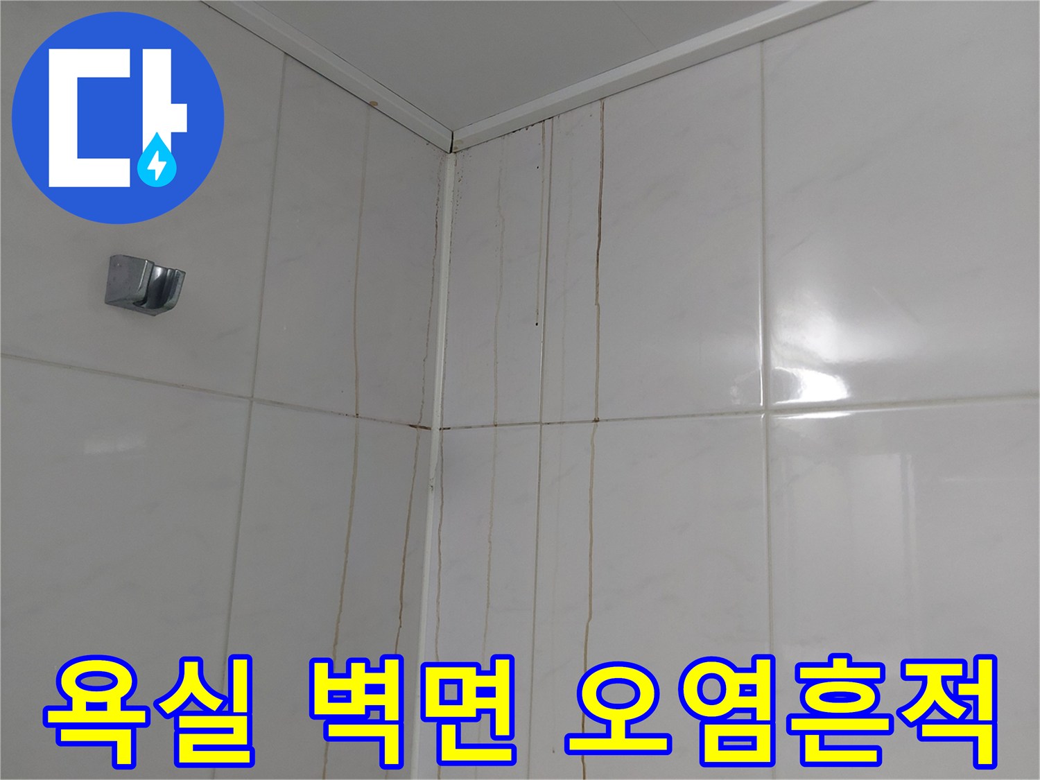 하얀색 욕실 타일에 수직으로 남은 노란색 물자국