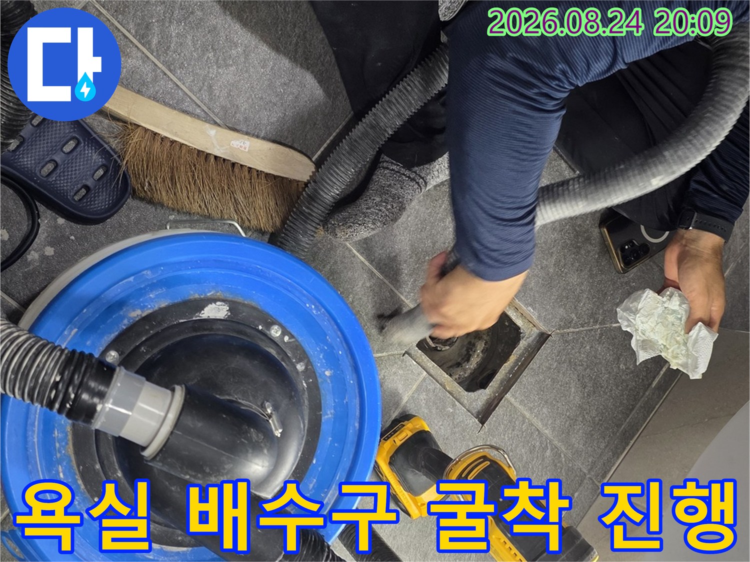 배수구 주변의 타일을 제거하여 누수 지점을 노출시킨 작업 현장 사진