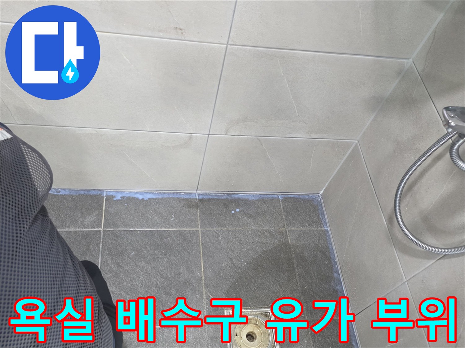 욕실 바닥의 배수구 유가와 샤워기 수전 근접 사진입니다.