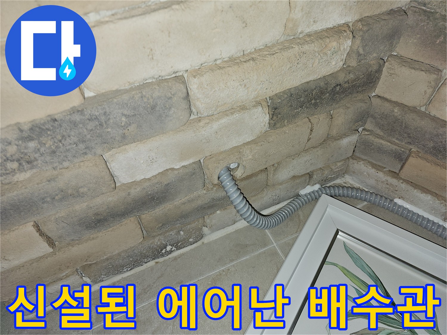 벽체 틈새로 연결된 회색 에어컨 드레인 호스