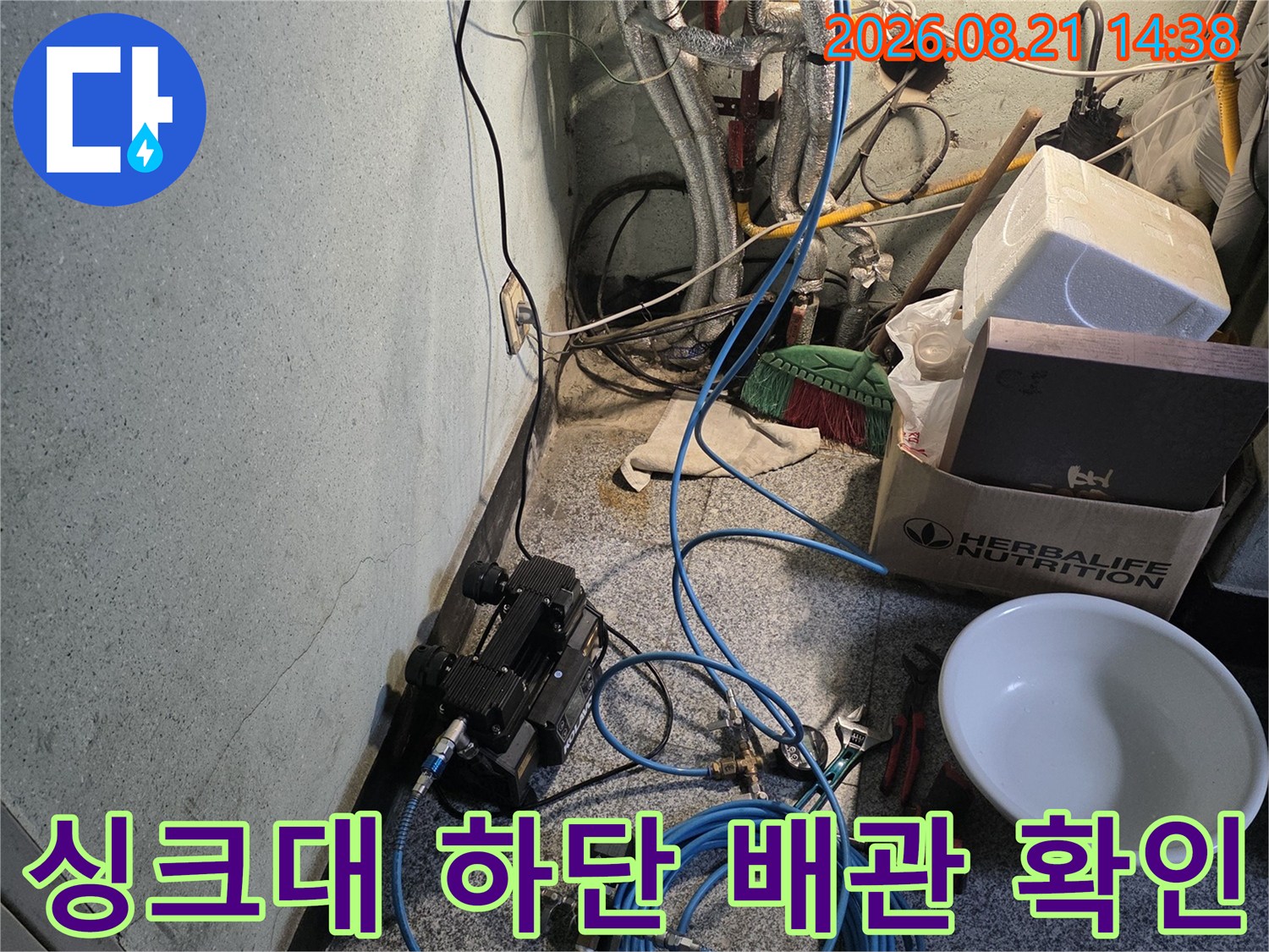 누수 탐지를 위해 싱크대 아래에 설치된 장비와 배관 모습입니다.