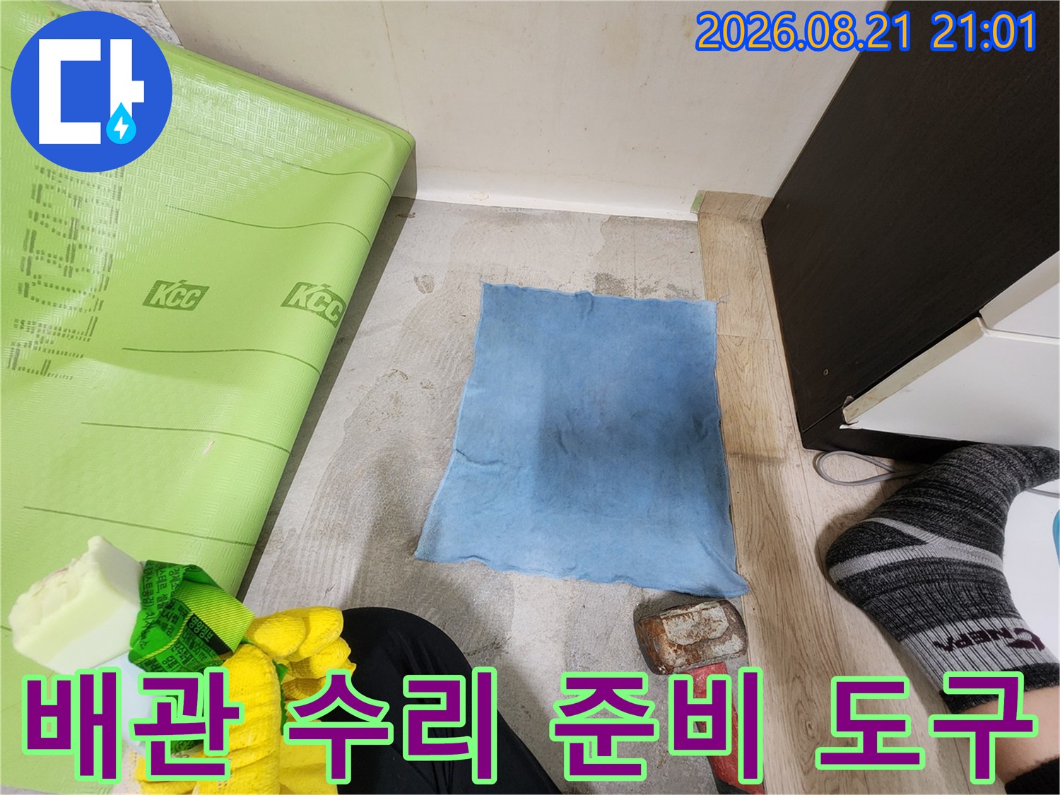 망치와 작업용 장갑이 놓여 있는 누수 보수 작업 현장 사진입니다.