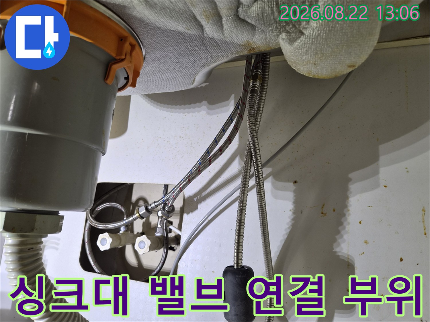 싱크대 하단 급수 밸브와 수전 호스 연결 부위를 근접 촬영한 사진입니다.