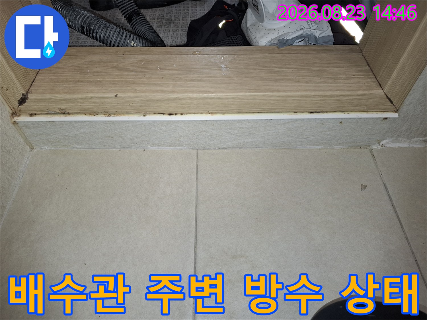 배수관과 타일 사이의 이물질 및 오염된 부위를 근접 촬영한 사진입니다.