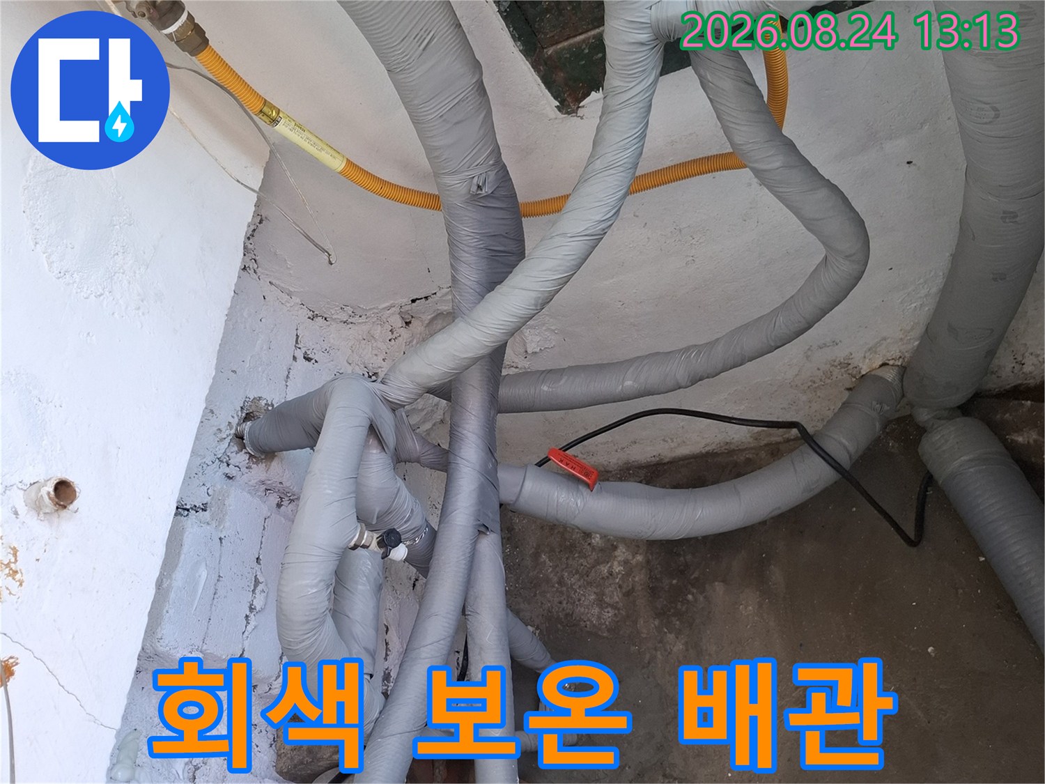 벽면 근처에 설치된 회색 보온재가 씌워진 배관들