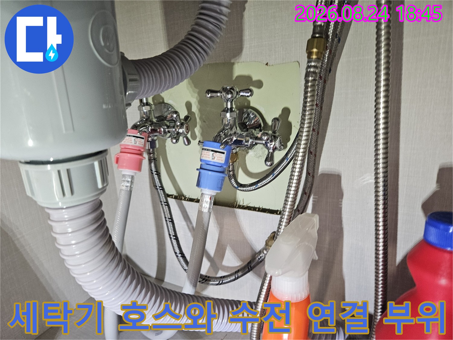 세탁실 벽면에 설치된 수도꼭지와 배관들의 복잡한 연결 구조를 보여줍니다.