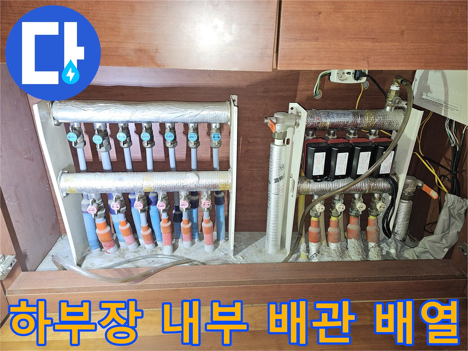 싱크대 아래 분배기와 연결된 각종 배관의 모습