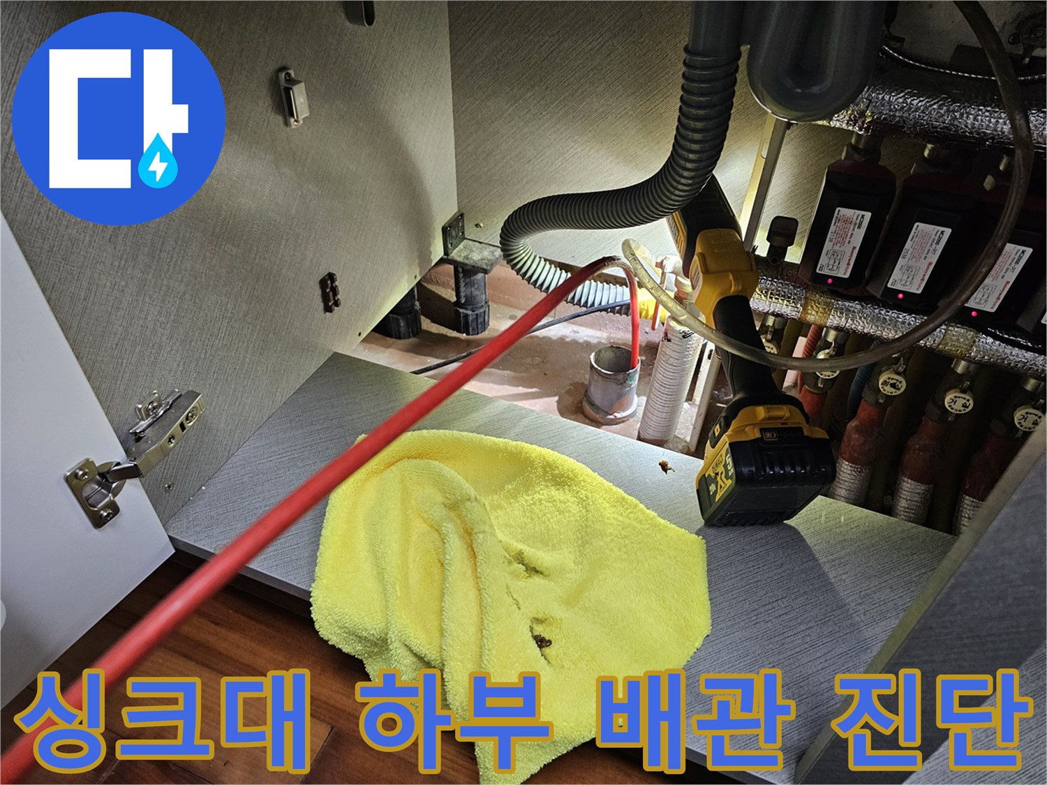 싱크대-하부장-내부의-복잡한-배관과-측정-도구들