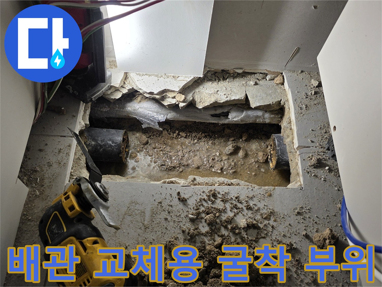 싱크대 아래쪽 바닥을 파내어 드러난 배관과 작업 도구