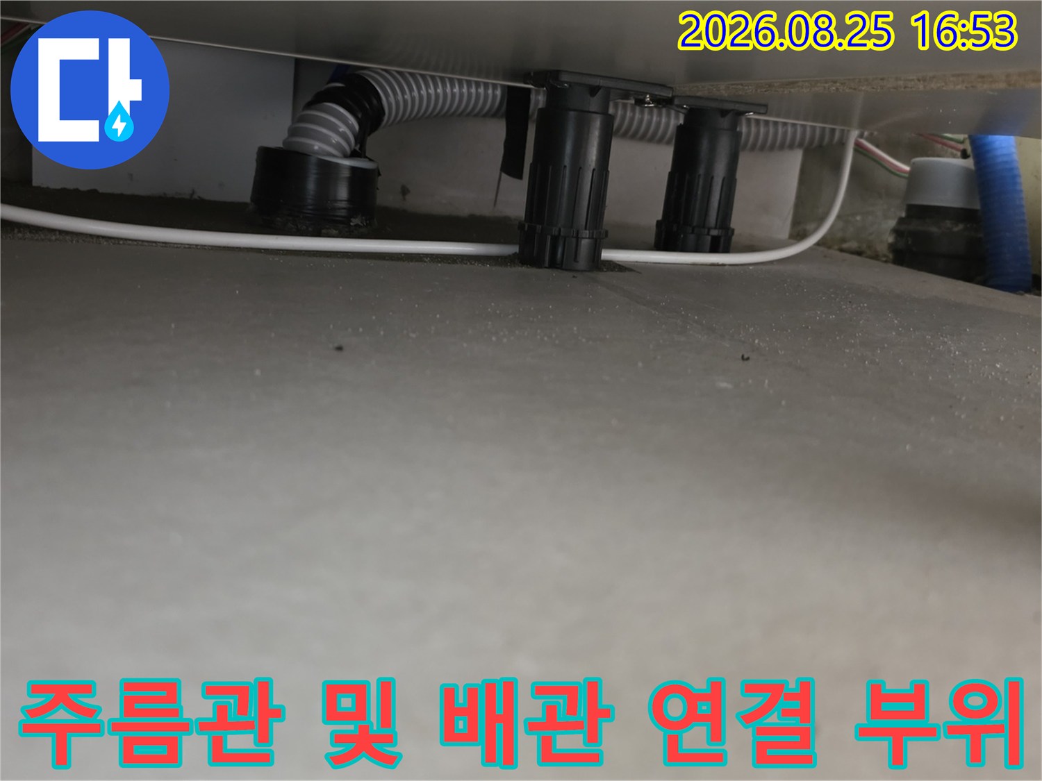 싱크대 아래쪽 회색 주름관과 검은색 배관 부속 상세 모습