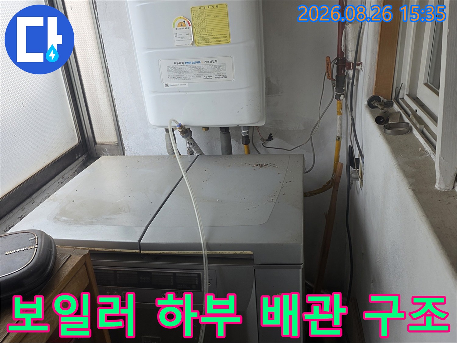 보일러 아래쪽의 은색 배관과 노란색 밸브 연결 부위를 촬영한 사진입니다.