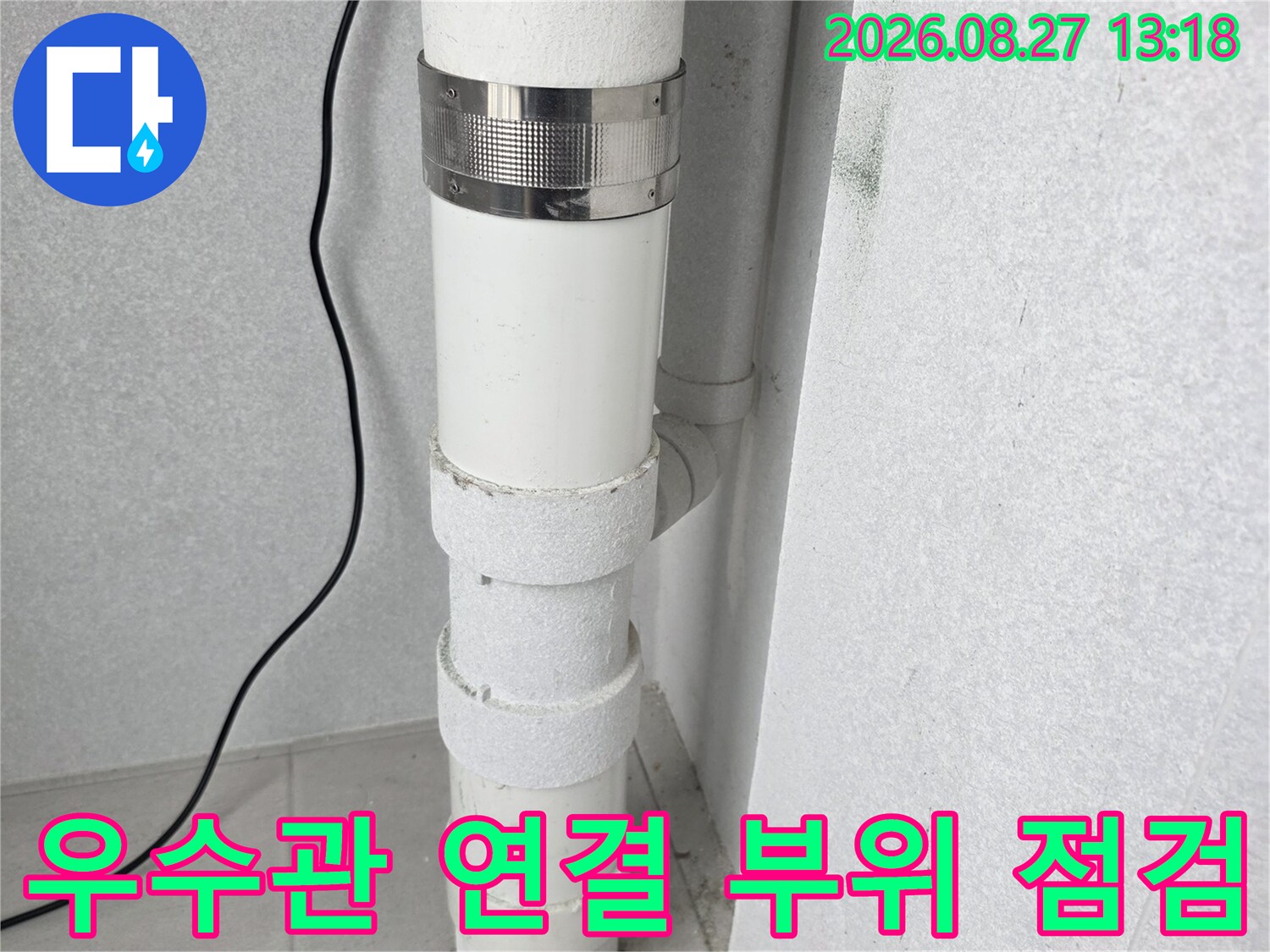 배관 연결부의 스테인리스 클램프와 하얀색 우수관 마감 상태