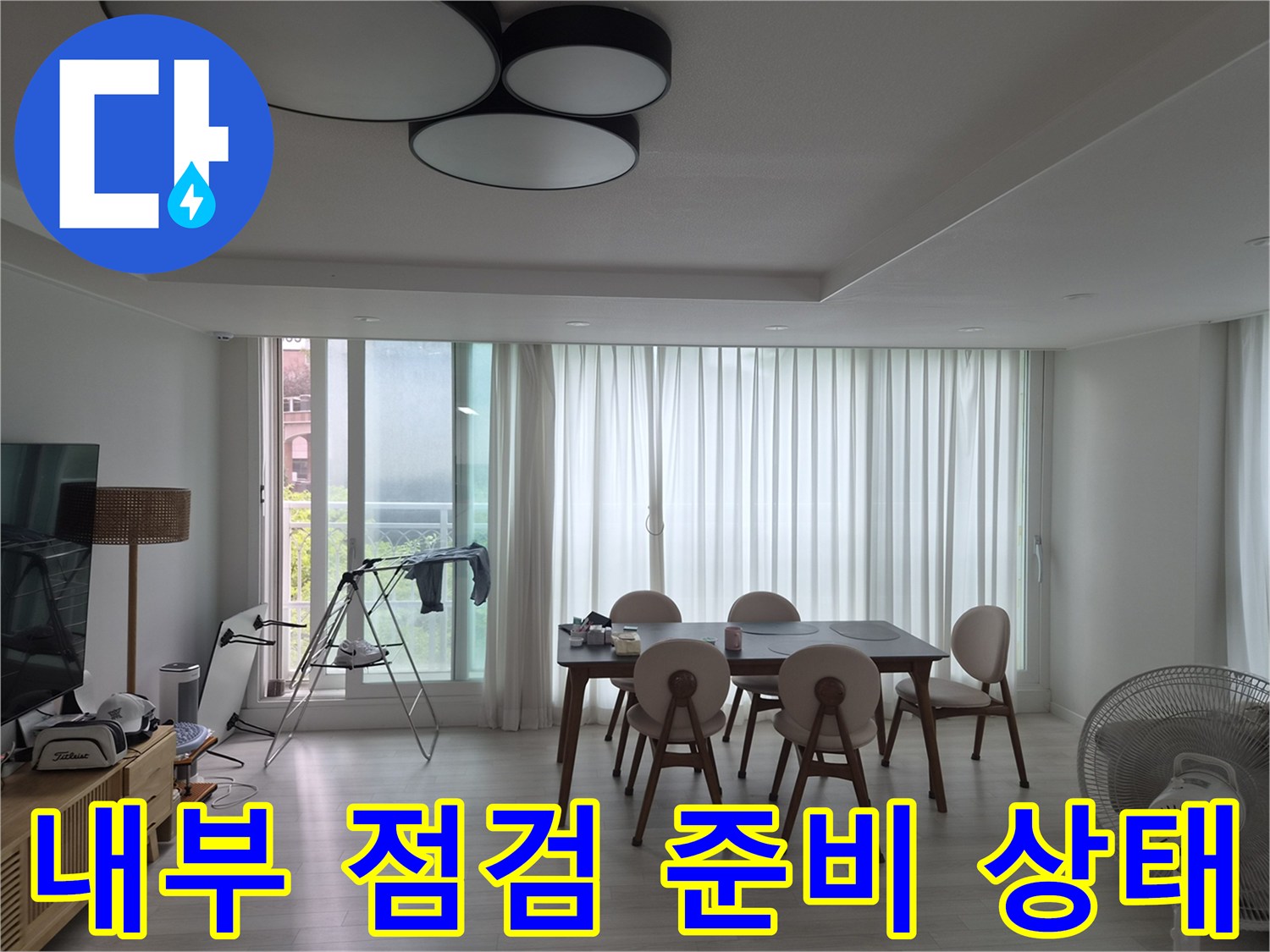 작업을 위해 거실 식탁 주변에 배치된 보조 조명과 장비들