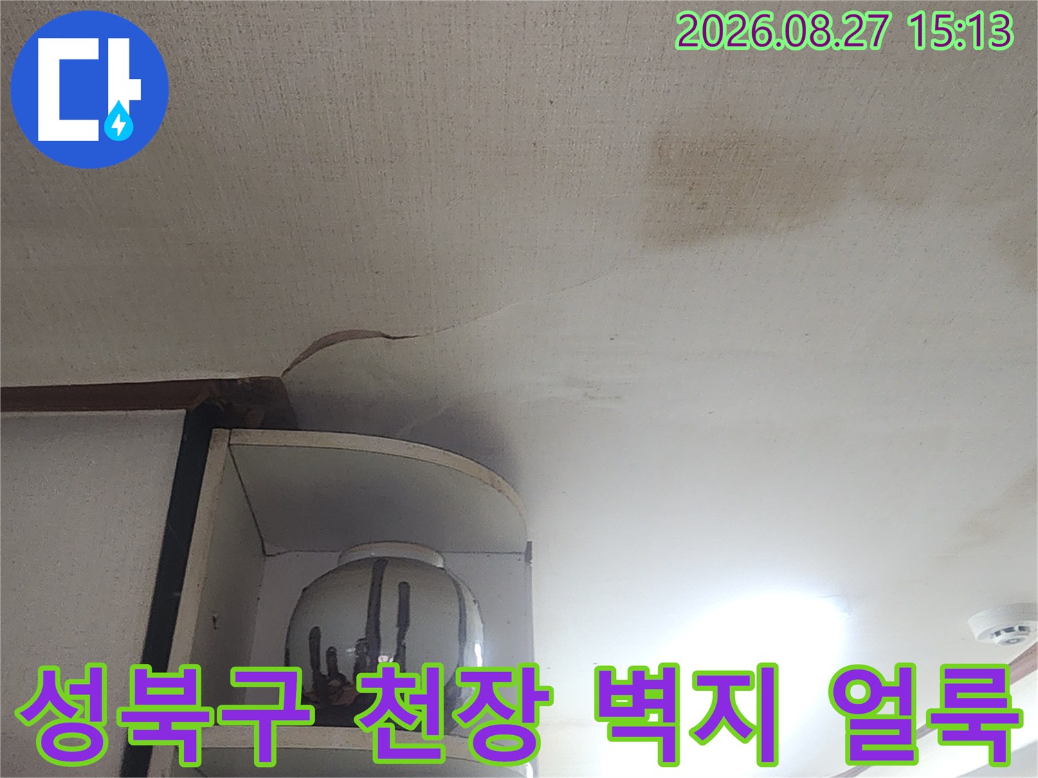 성북구 아파트 거실 천장의 벽지가 물에 젖어 변색된 모습입니다.