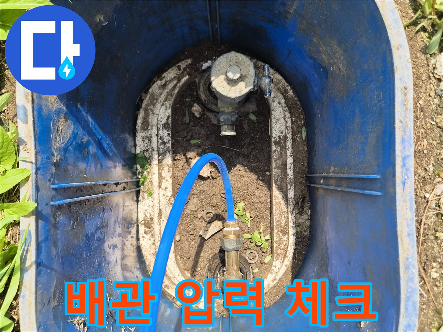 흙이 묻은 배관 부위와 연결된 파란색 호스 상세샷