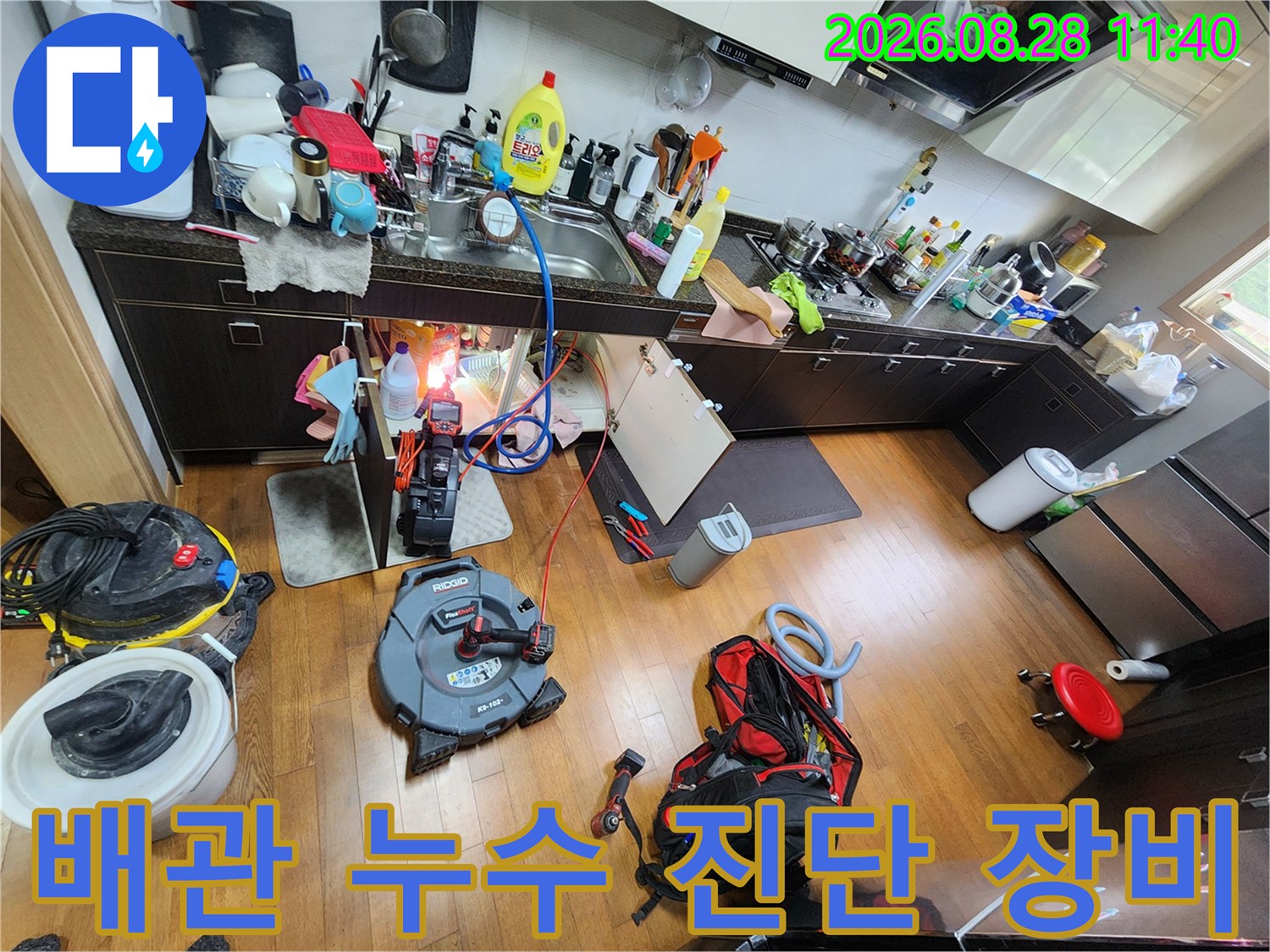 싱크대 하부 배관 점검을 위해 배치된 전문 누수 탐지 및 청소 장비들