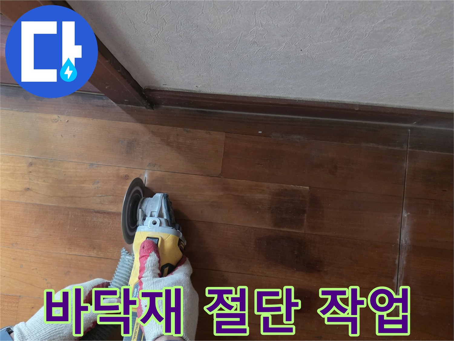 마루를 자르는 전동 공구와 작업자의 장갑 낀 손