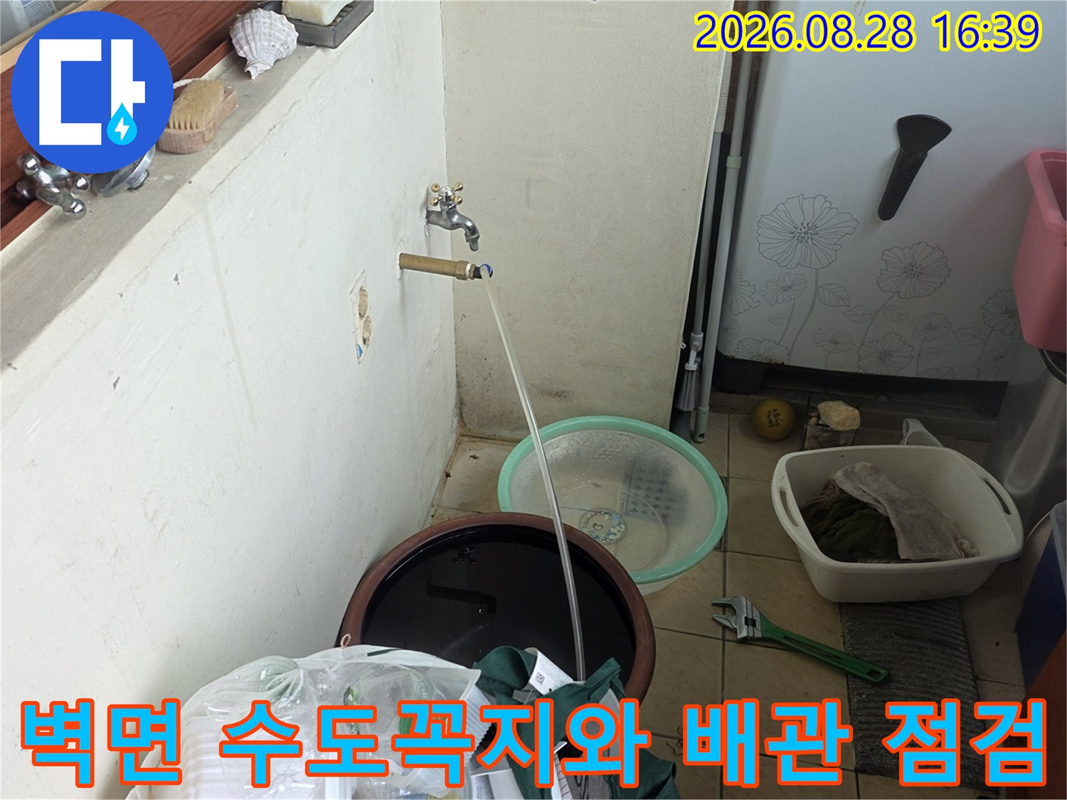 벽면에 설치된 수도꼭지-배관 연결 상태를 점검 중인 현장 모습입니다.