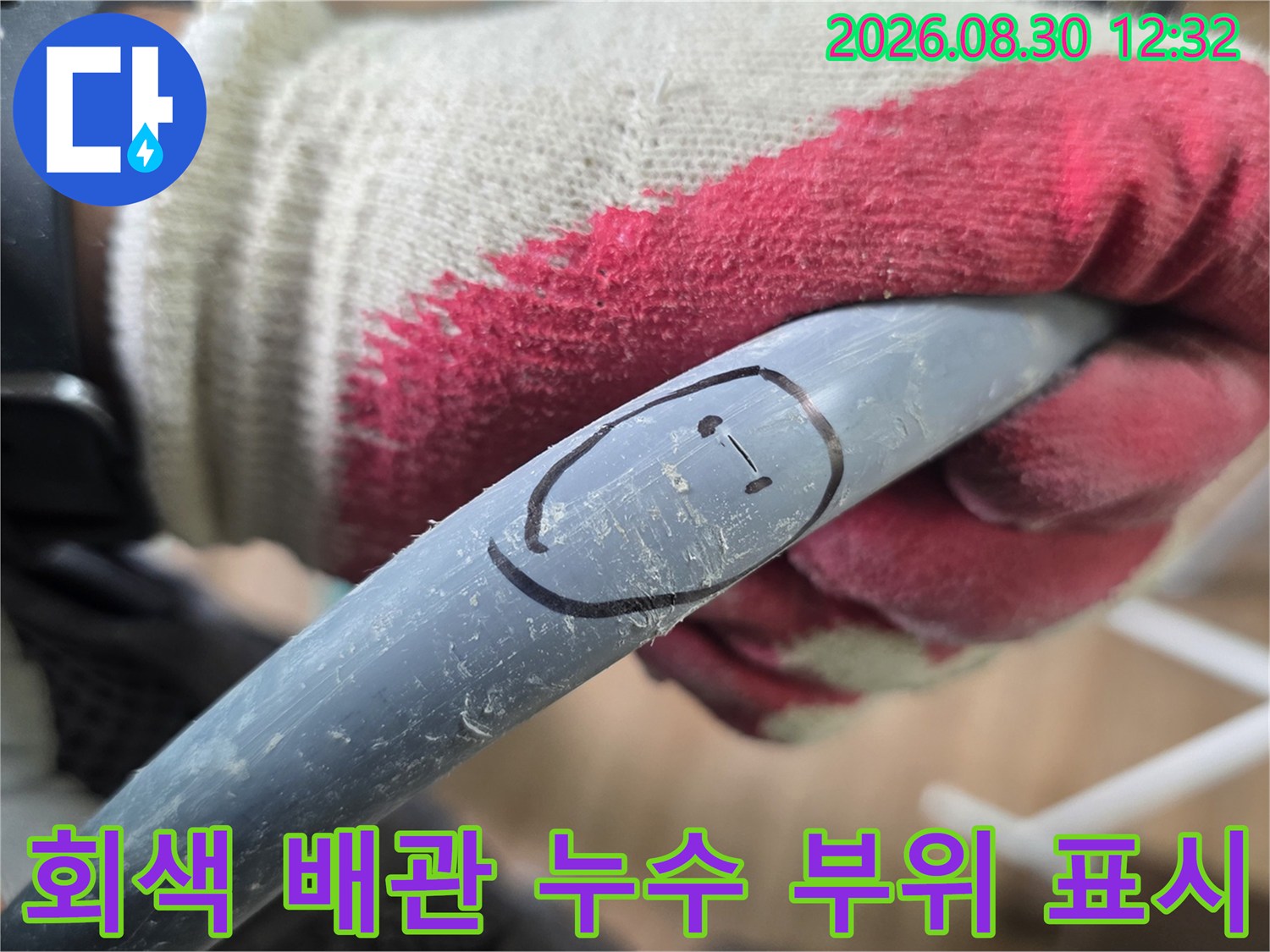 장갑을 낀 작업자가-회색 배관의 문제 지점을-표시하고 있습니다