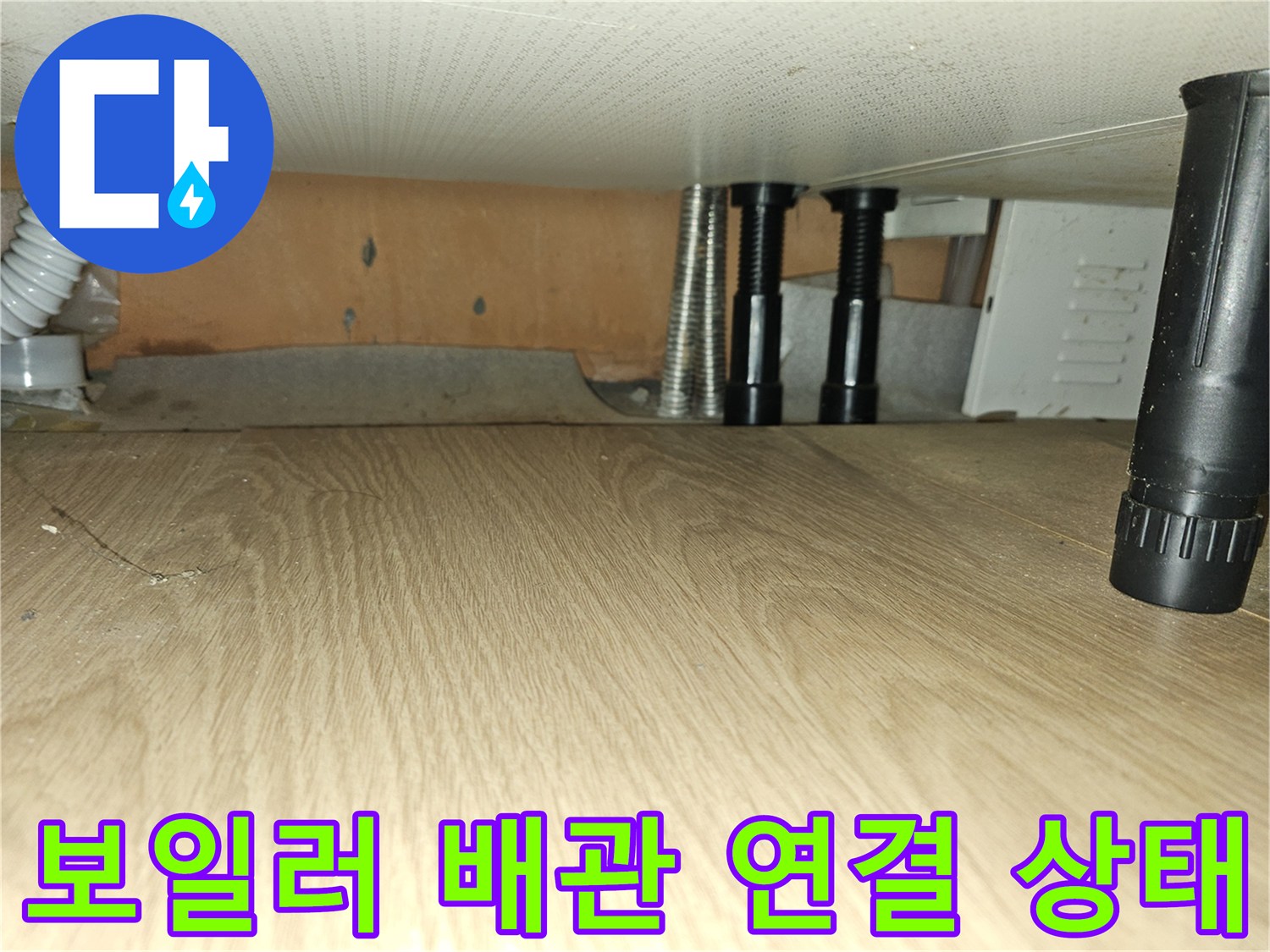 싱크대 하부장 내부의 은색 보온재 배관과 검은색 밸브 부위 상세 사진