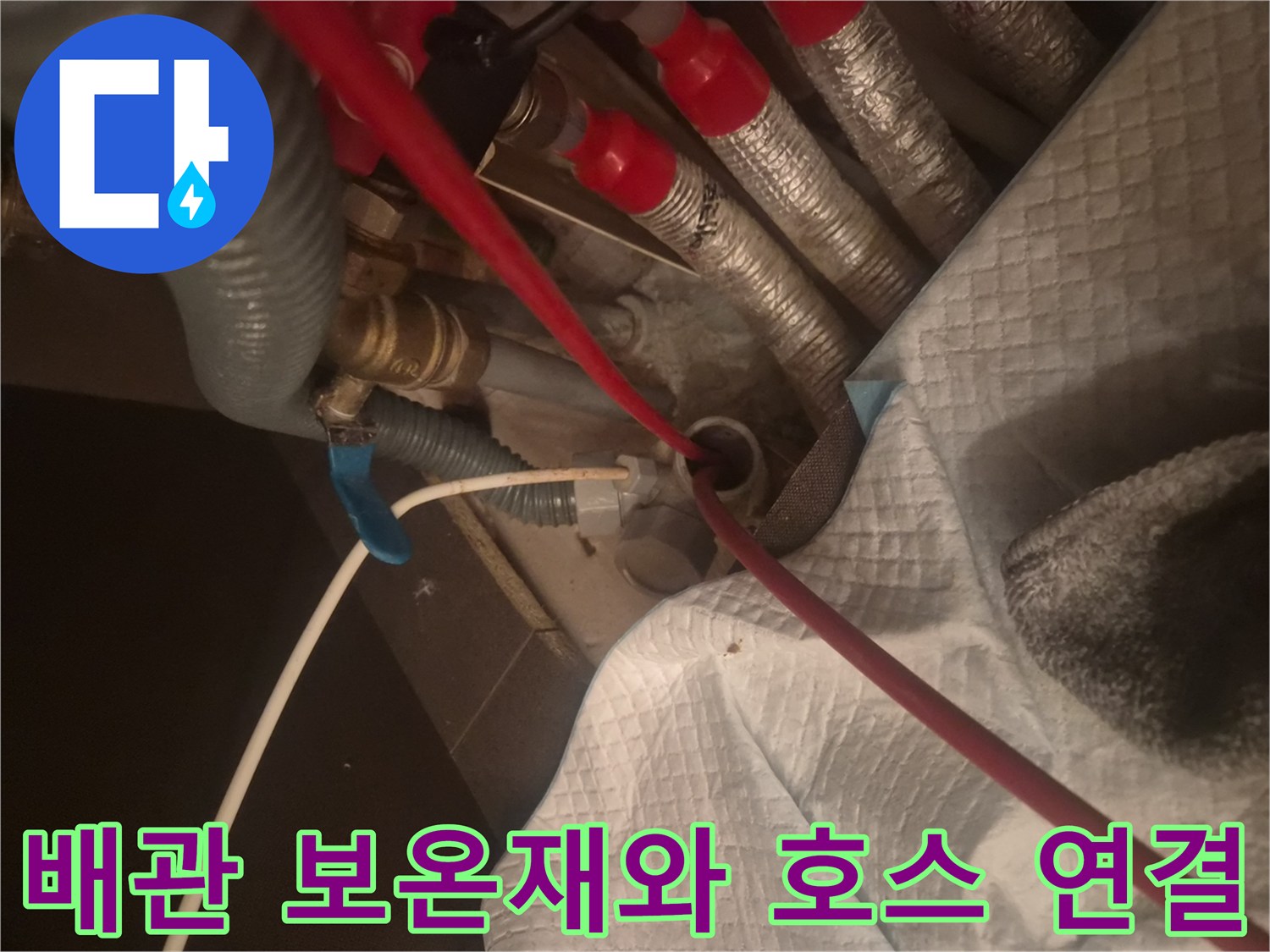 은색 보온재가 씌워진 배관과 붉은색 장비 호스가 놓인 현장