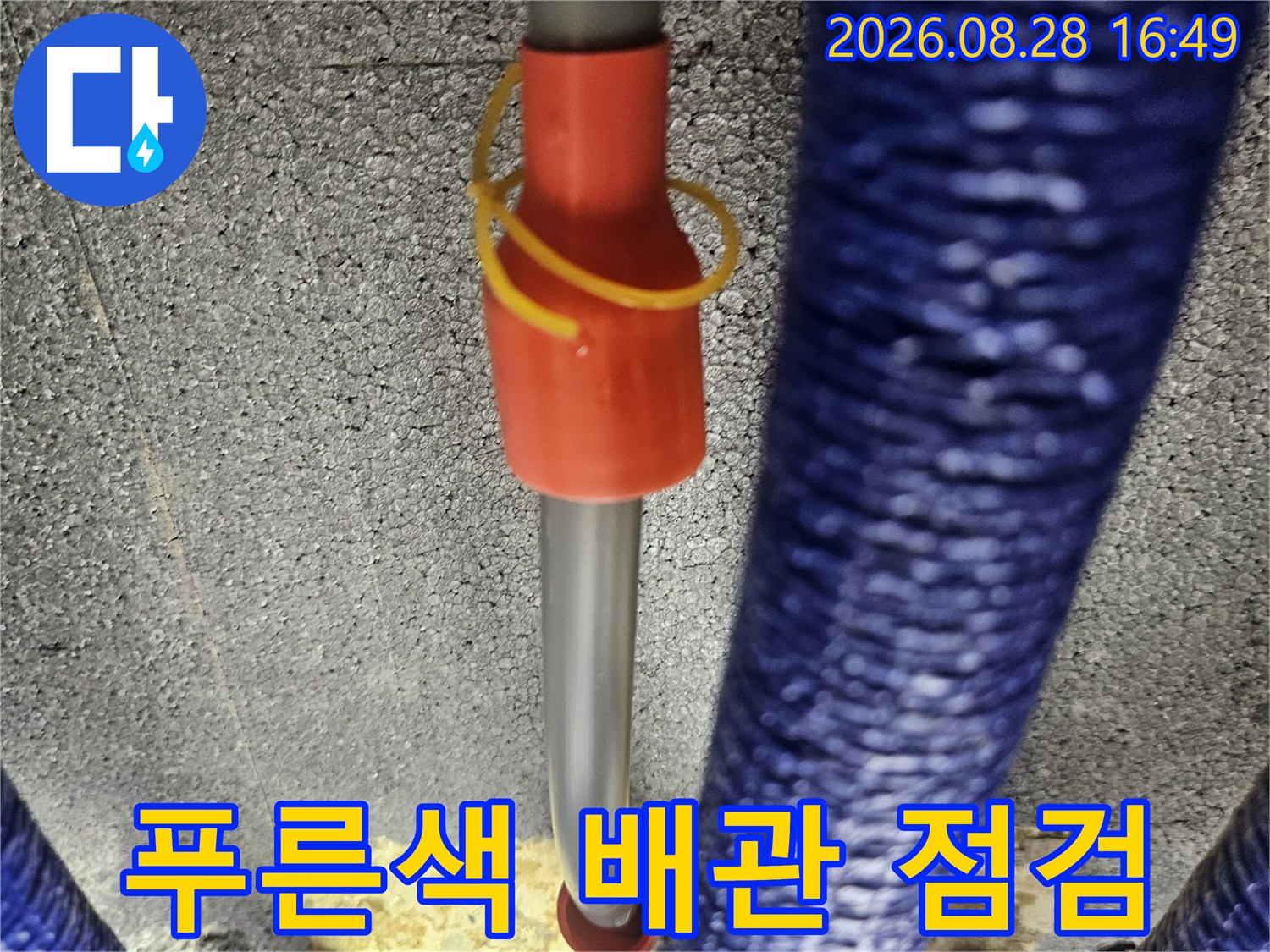 푸른색 보온재로 감싸진 배관과 타공된 벽면 내부의 모습입니다.