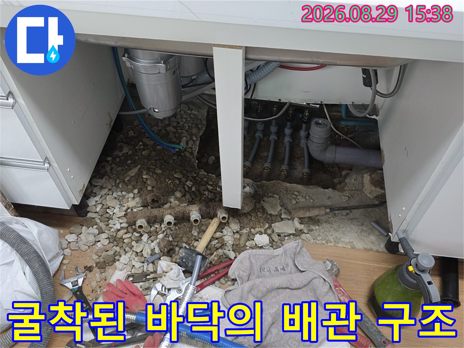 싱크대 하부 굴착 부위에 노출된 분배기와 주변 자재들입니다.