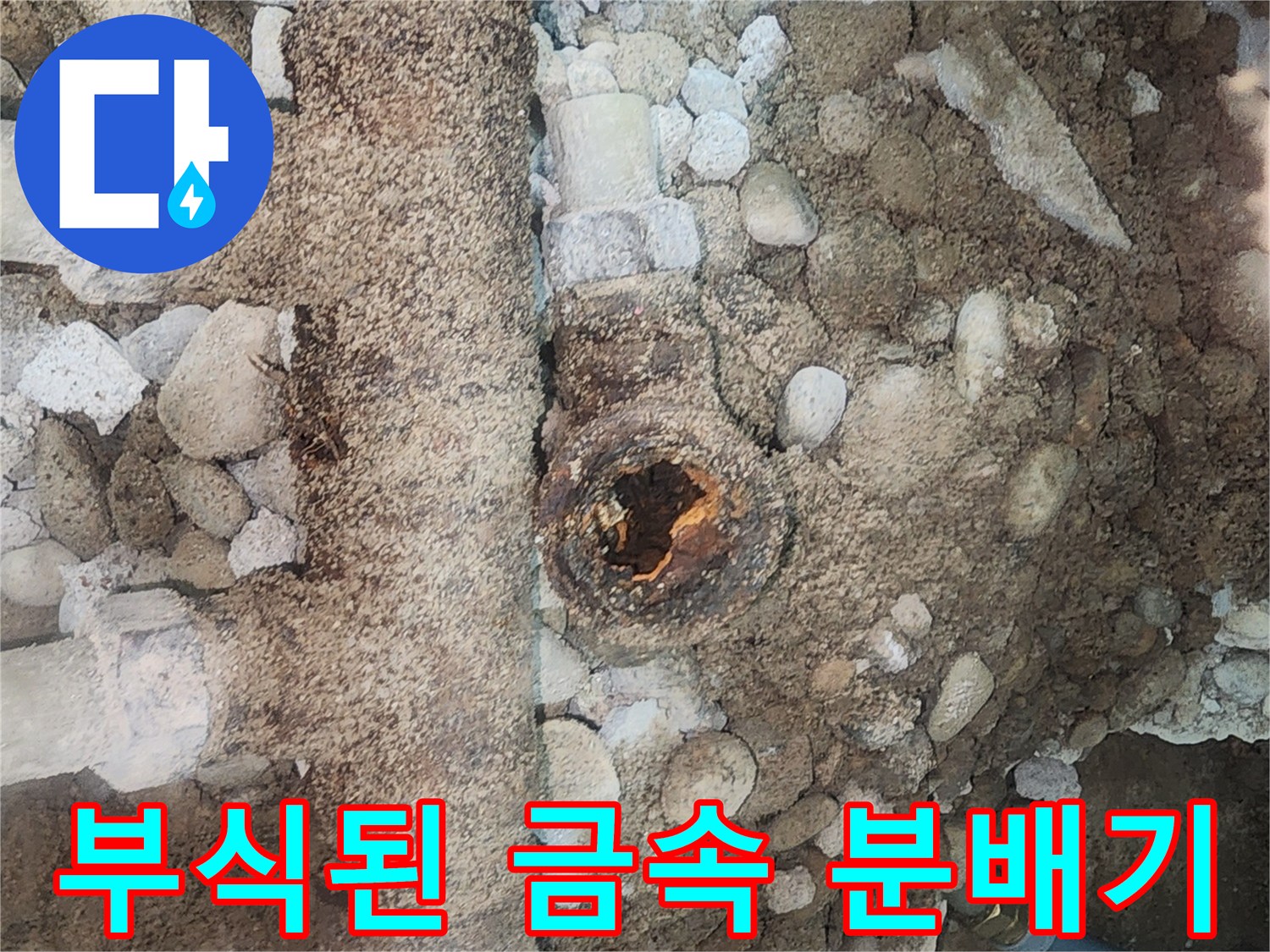 흙과 자갈 사이로 드러난 부식된 배관 분배기 상태