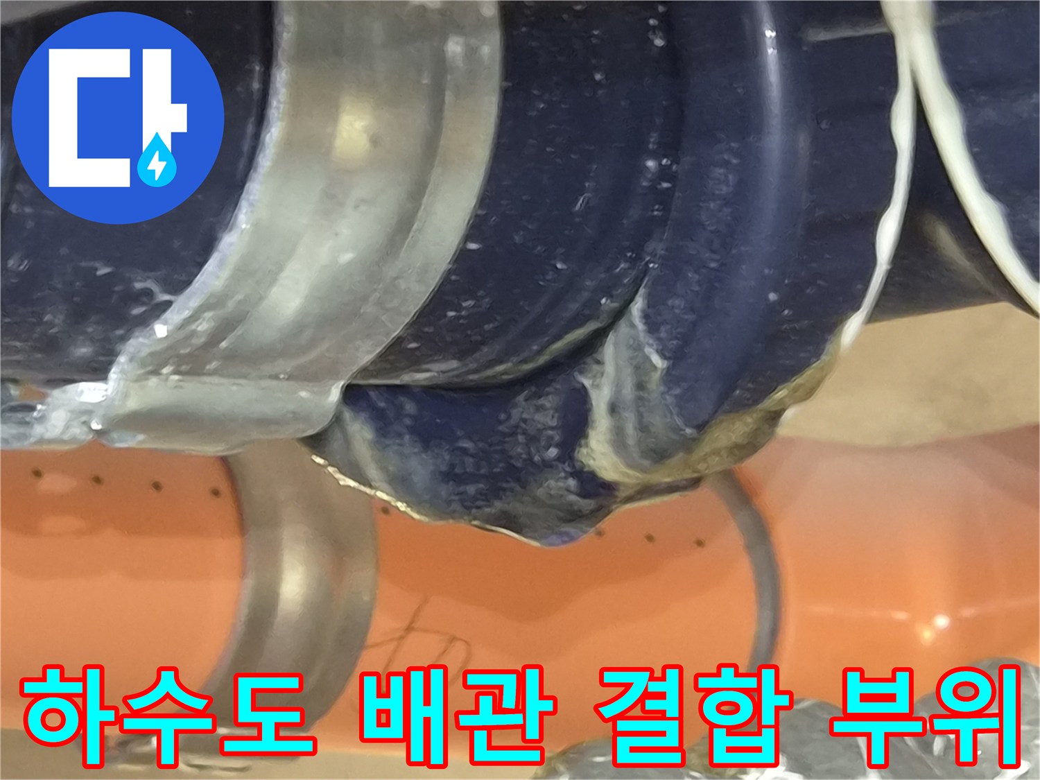 어두운 천장 속 하수도 배관의 연결 지점 상태를 보여주는 이미지입니다.