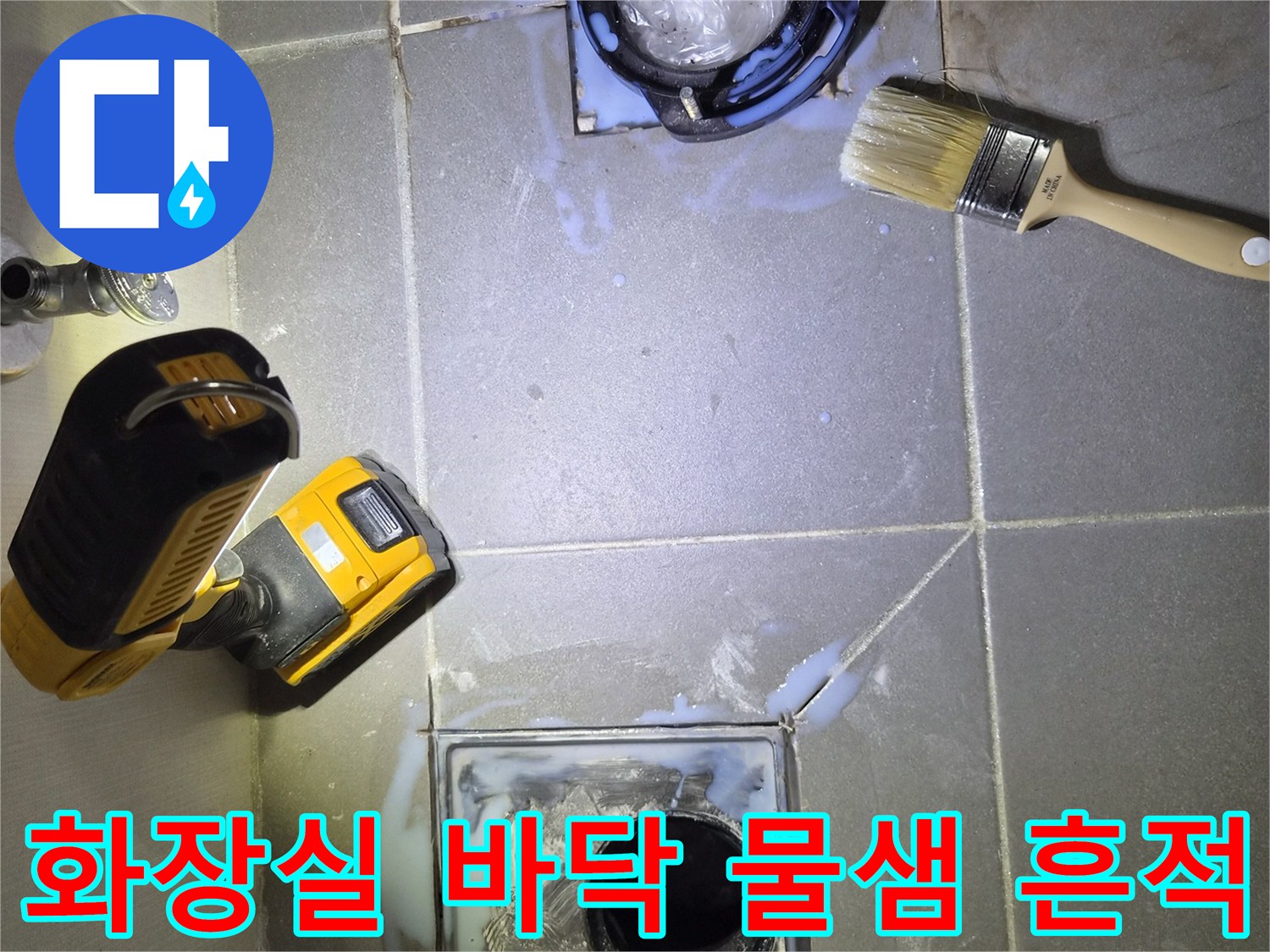 변기를 들어낸 자리의 배수구 주변 타일 오염 상태를 보여줍니다.