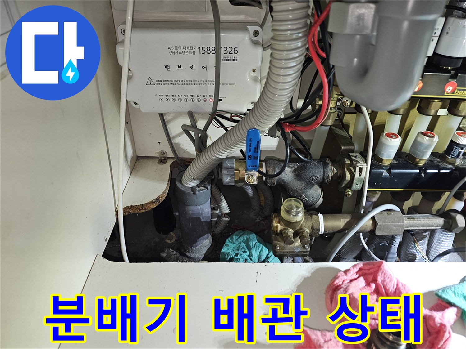 분당 백현동 아파트 주방 하부장 내부의 노후된 난방 분배기와 연결 배관 모습입니다.