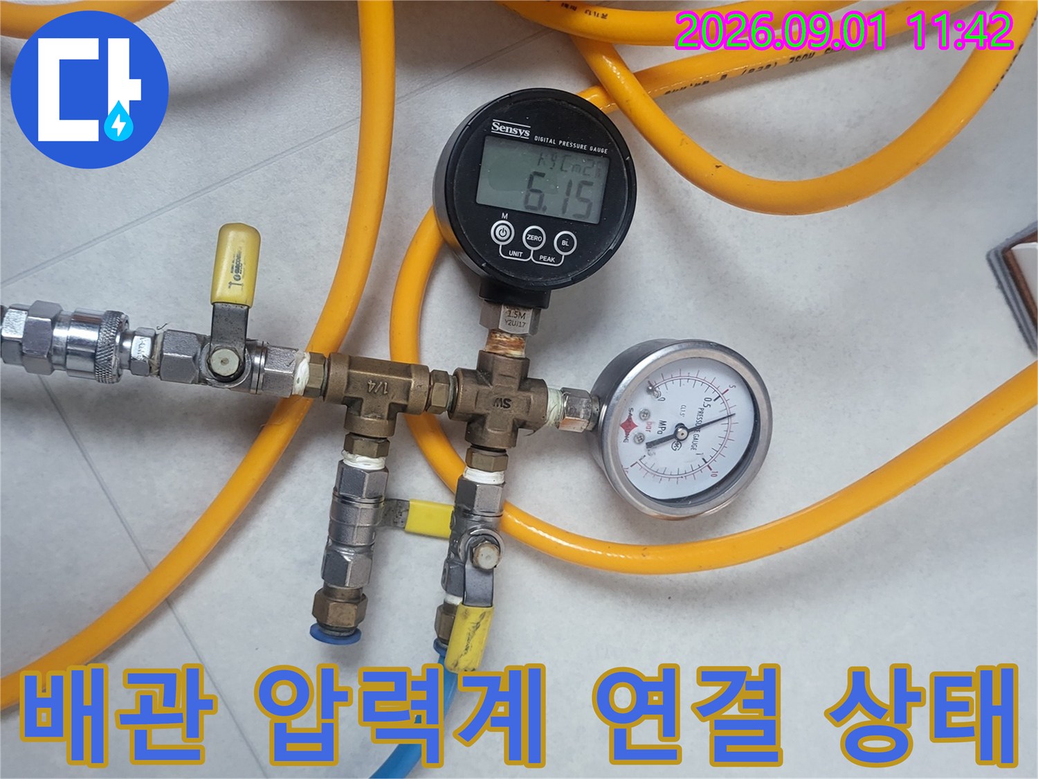 노란색 호스와 게이지가 연결된 배관 테스트 장비 세팅