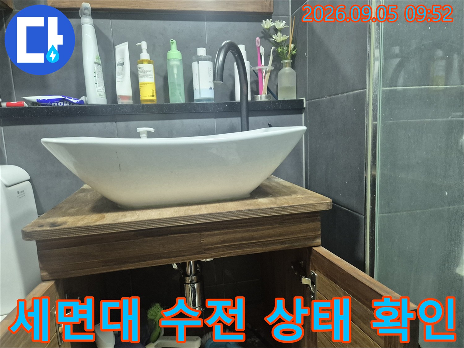 강남구 화장실 세면대 위쪽에 설치된 검은색 수전과 주변 욕실 용품 사진입니다.