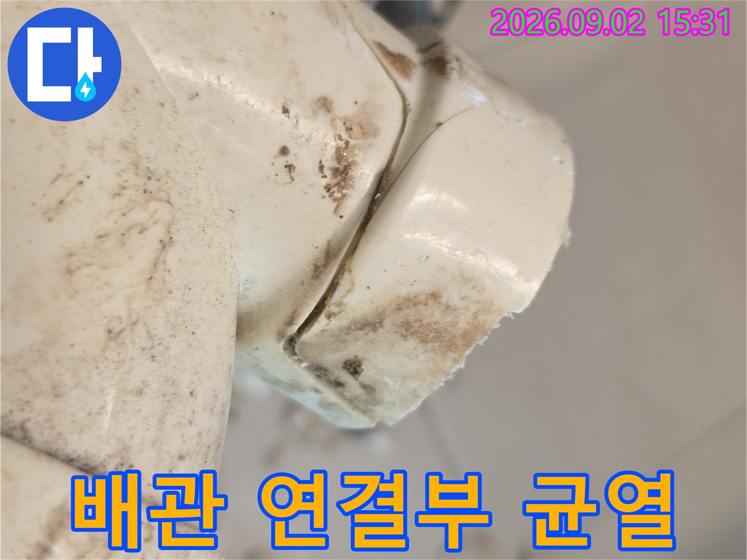 하얀색 배관의 분기점에 발생한-갈라짐과 흙먼지 오염입니다