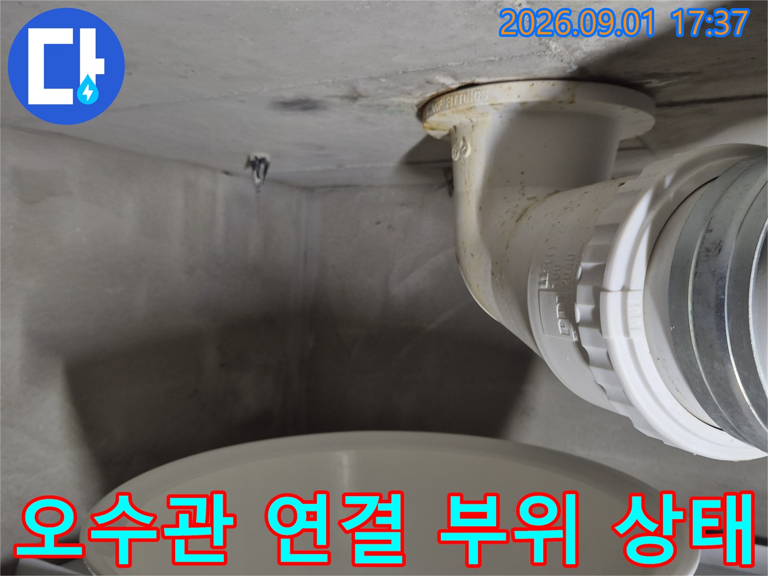 변기 오수관과 벽면 배관의-연결 상태를 근접하여 촬영한 이미지입니다.