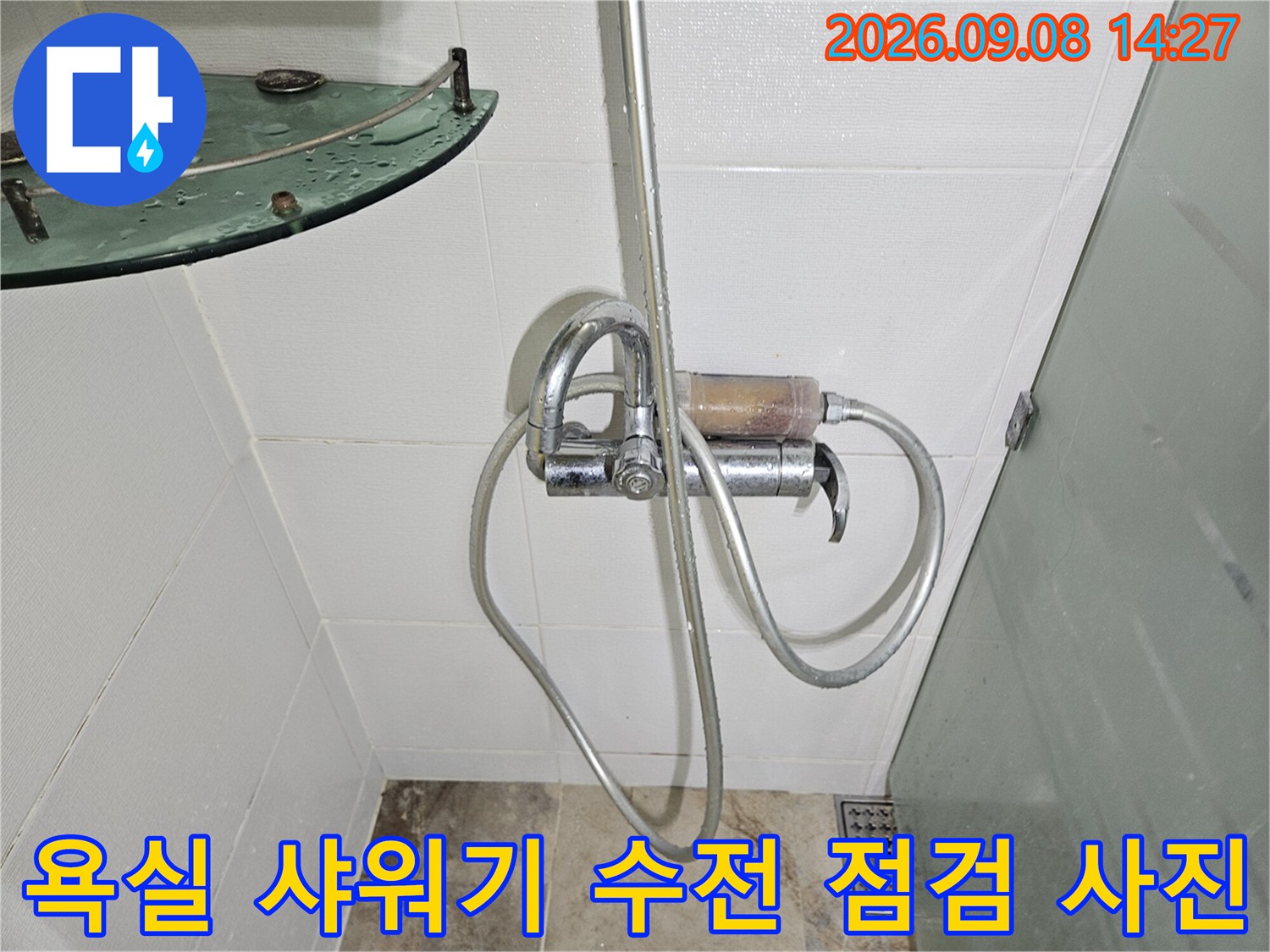 하얀 타일 배경의 샤워기 수전 및 호스 연결부 상세 촬영