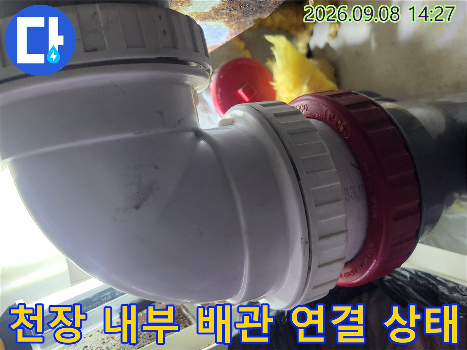 화장실 천장-배수관 엘보 부속과 배관의 결합 상태를 근접 촬영한 사진