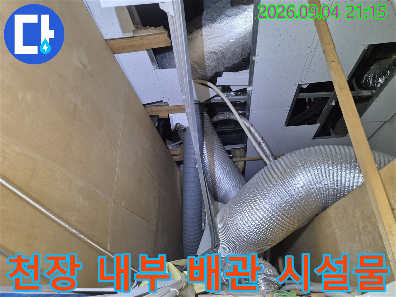 상가 천장 점검구 안쪽의 은색 보온재 배관과 드레인 라인 시설물입니다.