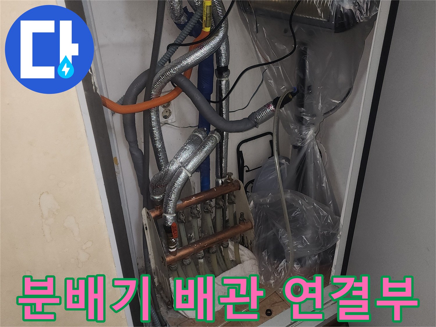 보일러 하단에 위치한 은박 보온재가 씌워진 난방 및 온수 분배기 상세 사진