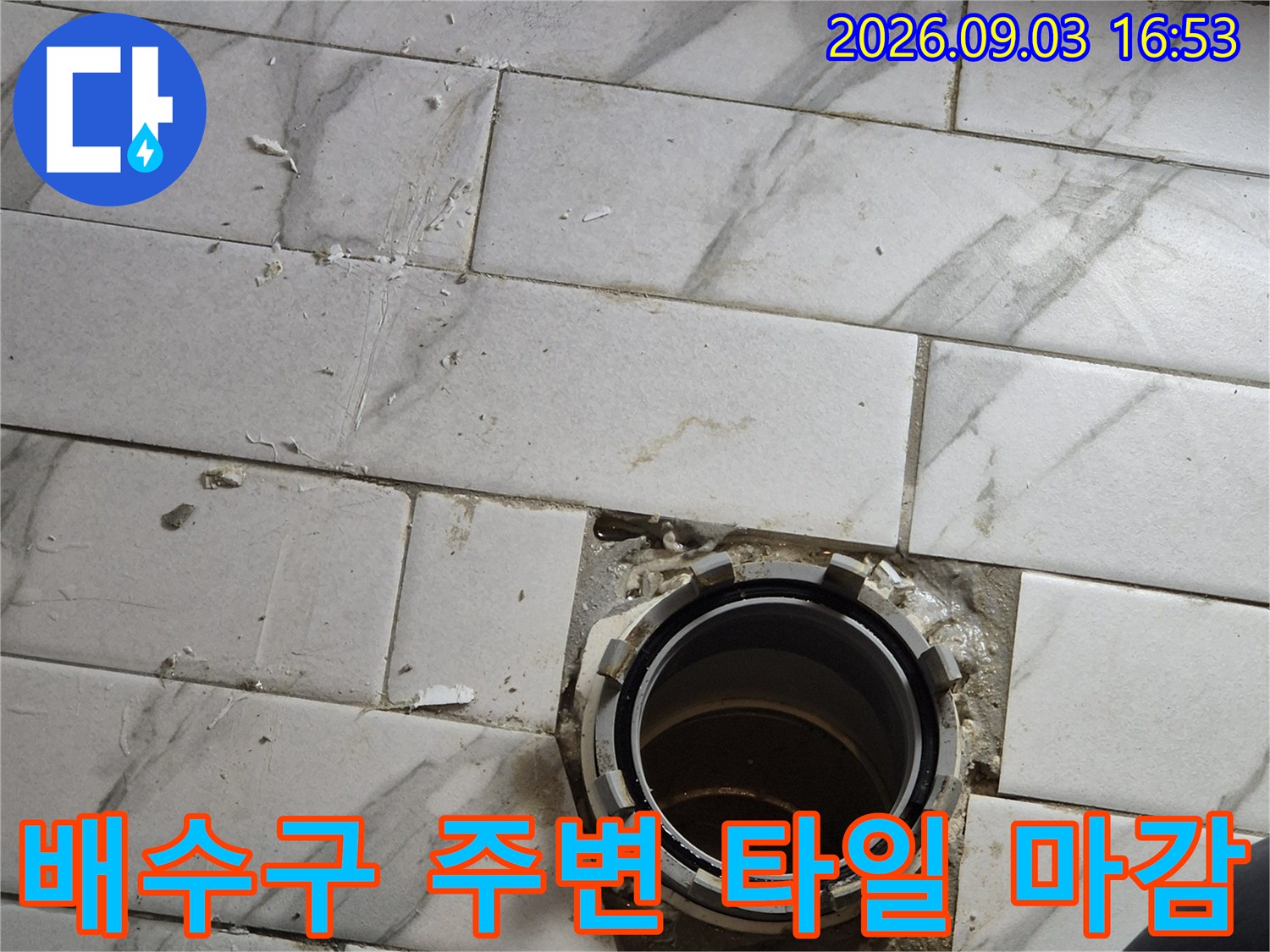 탈거된 배수구 부근의 타일과 노출된 배관 연결부 사진입니다.