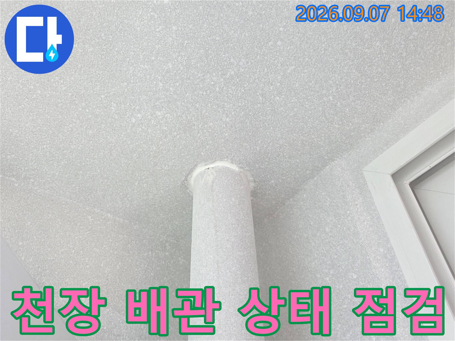 흰색 우수관과 천장 면의 접합부를 촬영한 사진입니다.