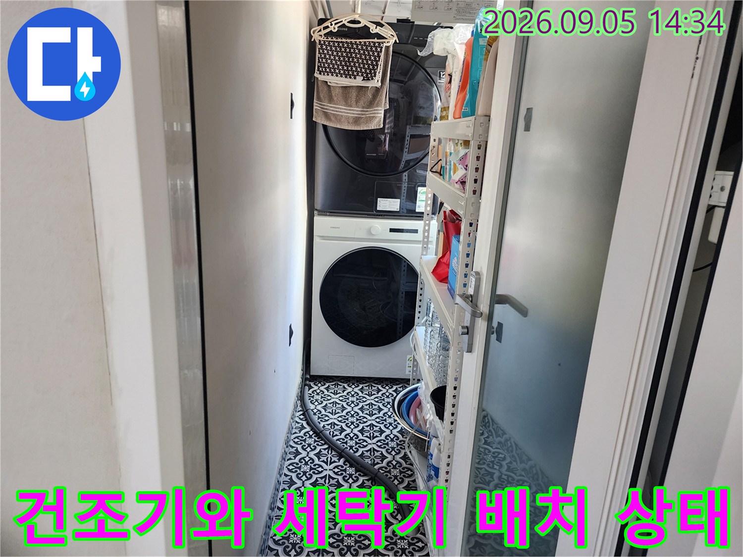세탁기 상단에 건조기가 적재된 다용도실 내부의 모습입니다.