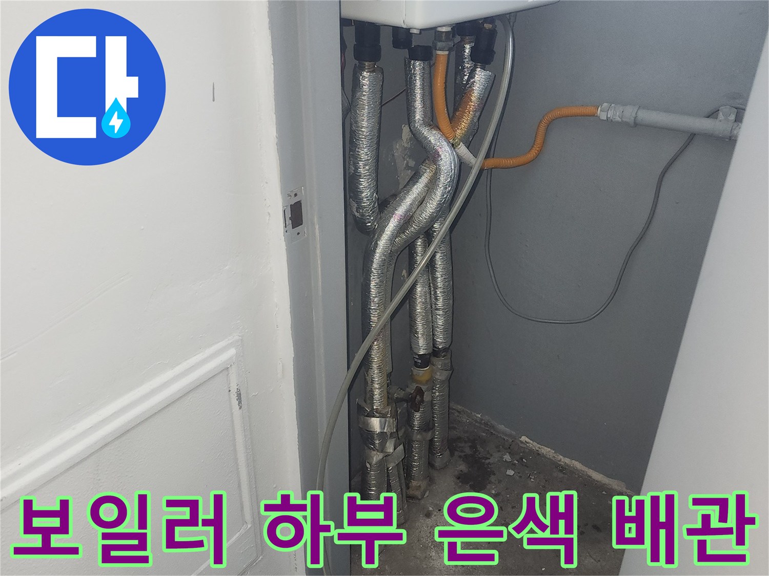 보일러 본체 아래 설치된 금속재질의 유연한 배관들