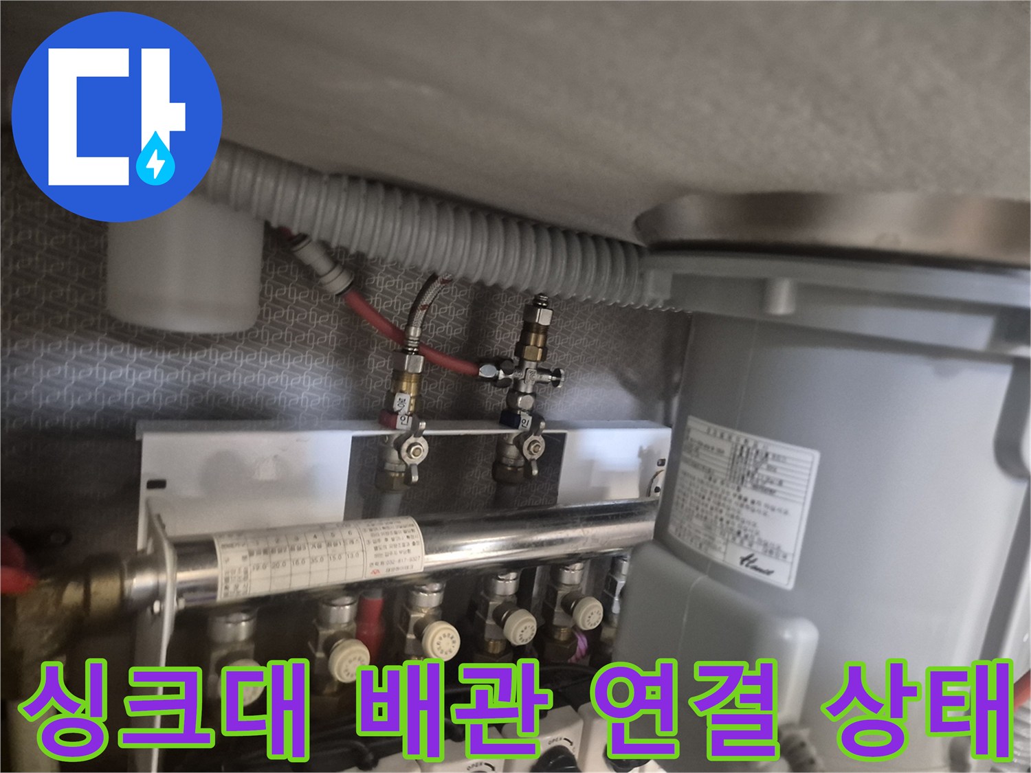 싱크대 하부장 내부의 수전 배관과 정수기 필터 연결 부위 모습