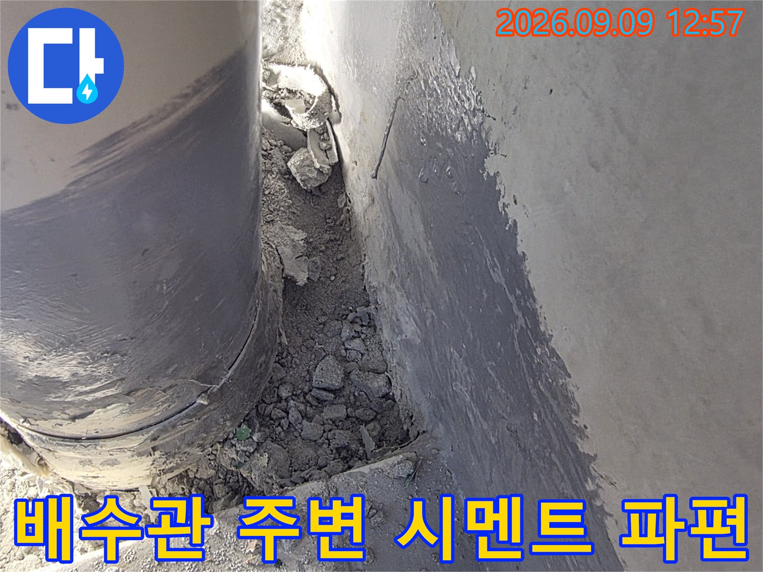 배수관 주위에 흩어진 시멘트 조각과 마감재 모습입니다.