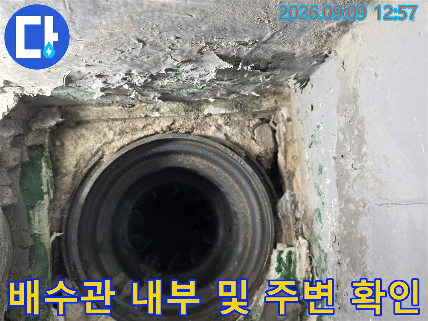 하수도 배관 입구와 주변 마감재의 파손 상태를 점검 중인 모습