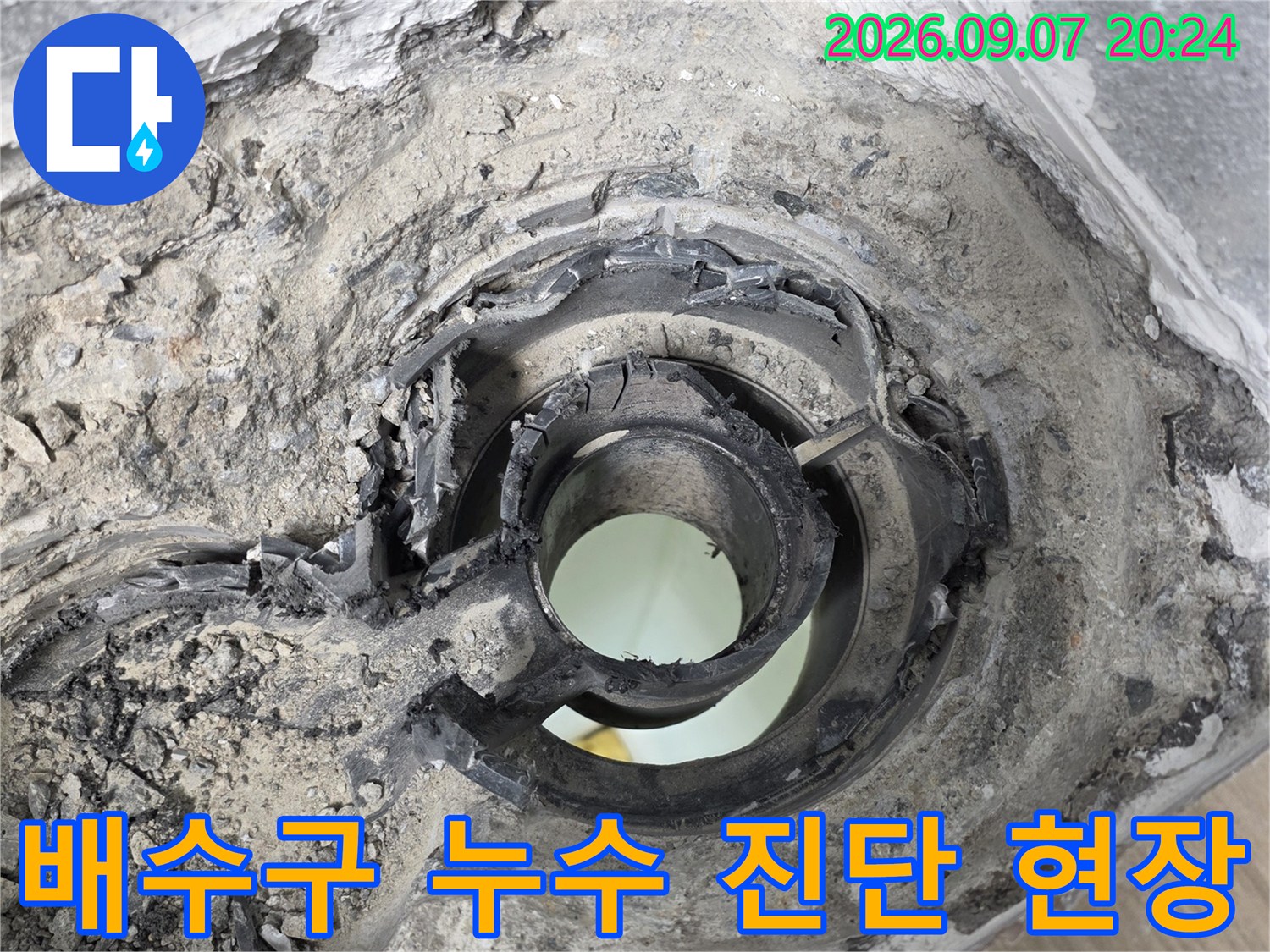 배수구 근처 배관의 노후된 상태와 틈새를 촬영한 사진입니다.